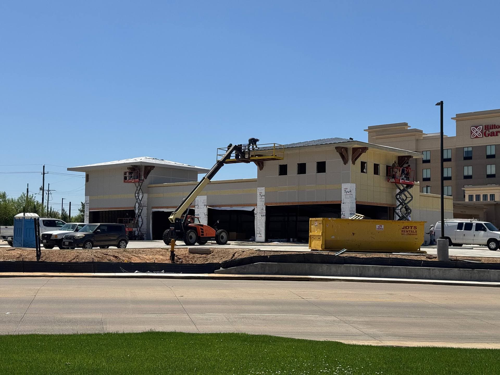 A JOTS Rentals roll-off dumpster placed on a residential driveway